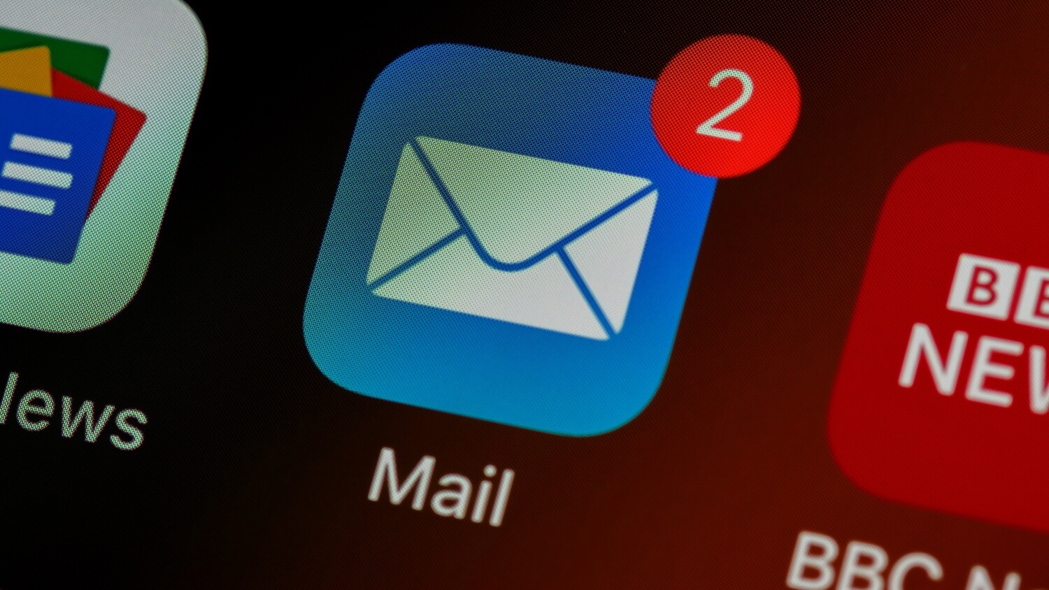 Close-up of the Apple Mail app icon on a smartphone screen showing two unread email notifications.